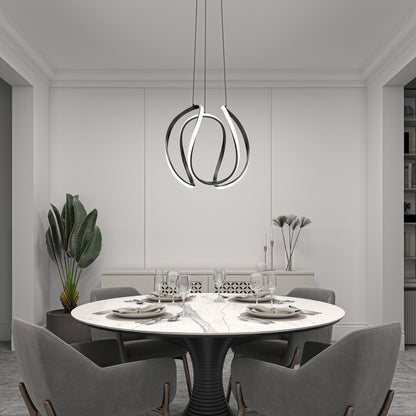 A modern dining room features a round marble table for four, grey chairs, a Vivaldi Big LED pendant light by Artika, a large potted plant, and minimalistic decor in neutral tones.