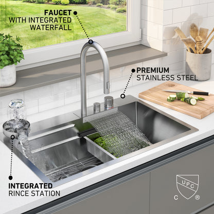 The Artika Neoflow single bowl stainless steel sink features a tall waterfall faucet, an integrated rinse station, and a cutting board holding chopped cucumbers and a knife beside the sink.