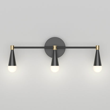 The Artika Wayden LED mid-century bathroom vanity light features three black and gold cone-shaped fixtures with glowing bulbs on a horizontal bar, mounted to a round wall plate against a light gray background.