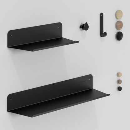 The Artika Sonokit set of shelves and hooks for Sonolok and Sonofold wall panels features minimalist black shelves and hooks, plus black and wood pegs arranged vertically, offering a sleek storage solution with quick installation.