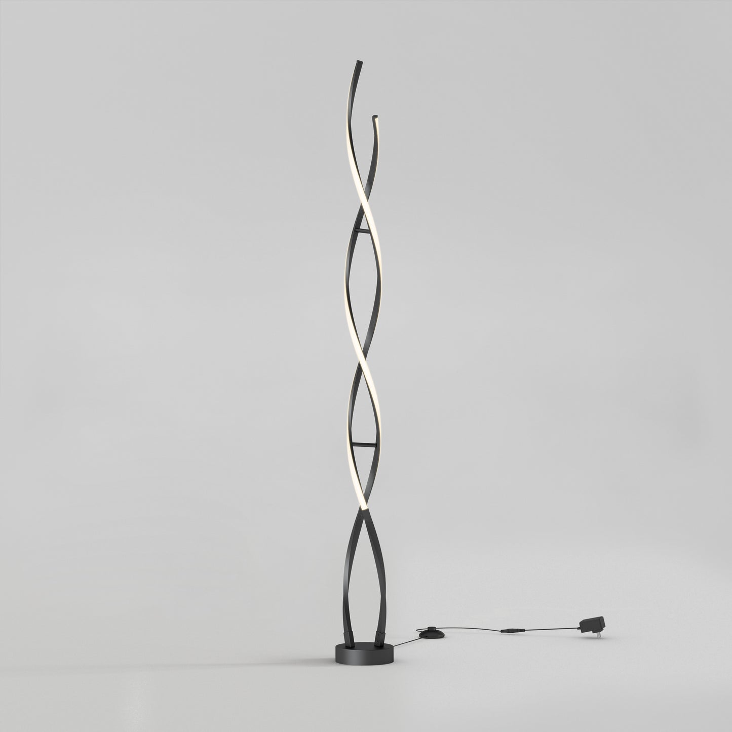 The Artika Swirl modern LED floor lamp features two black intertwining curved stems, one emitting soft white light. It stands on a round base with a visible plug-in cord, set against a plain light gray background.