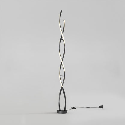 The Artika Swirl modern LED floor lamp features two black intertwining curved stems, one emitting soft white light. It stands on a round base with a visible plug-in cord, set against a plain light gray background.