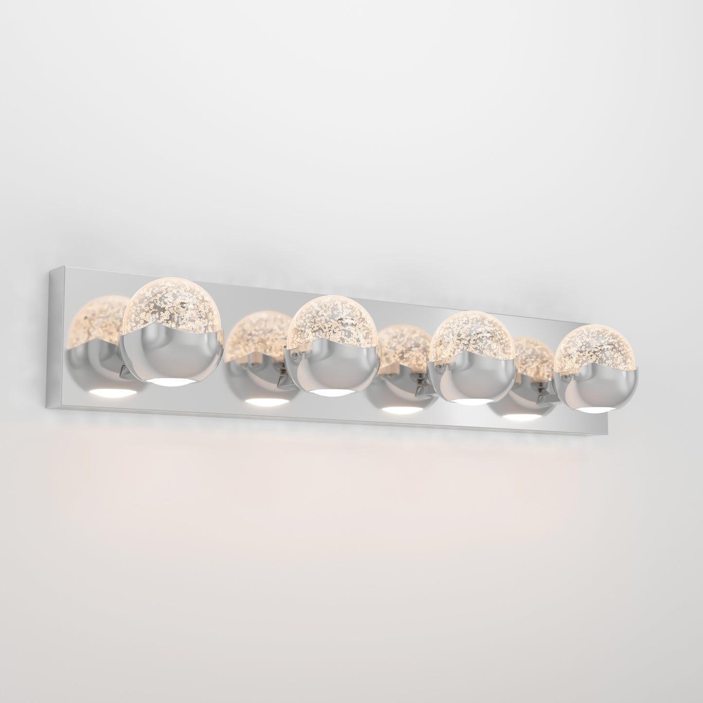 The Artika Oracle LED bathroom vanity light features five round glass and chrome bulbs on a sleek rectangular chrome base, casting a soft glow against the wall.
