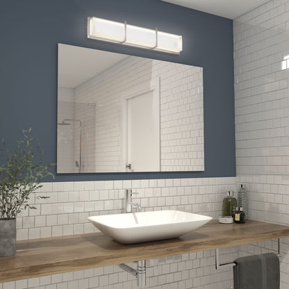 Modern bathroom with white square tiles, a wooden countertop, a rectangular mirror, and a vessel sink. Above the mirror is the Artika Subway LED bathroom vanity light. A plant and toiletries sit on the countertop.
