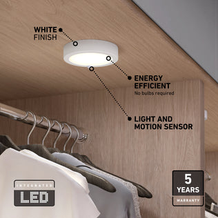 The Artika Accent under cabinet LED light 3CCT is shown installed in a wooden closet above shirts, featuring a white finish, motion and light sensors, energy efficiency, and a 5-year warranty.
