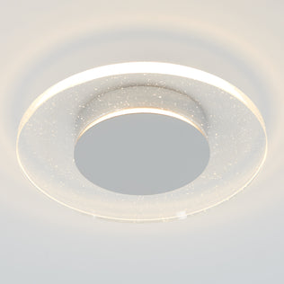 The Artika Essence Disk LED flush mount features a frosted, semi-transparent ring with tiny star-like dots, casting a soft white glow on pale ceilings for a modern look.