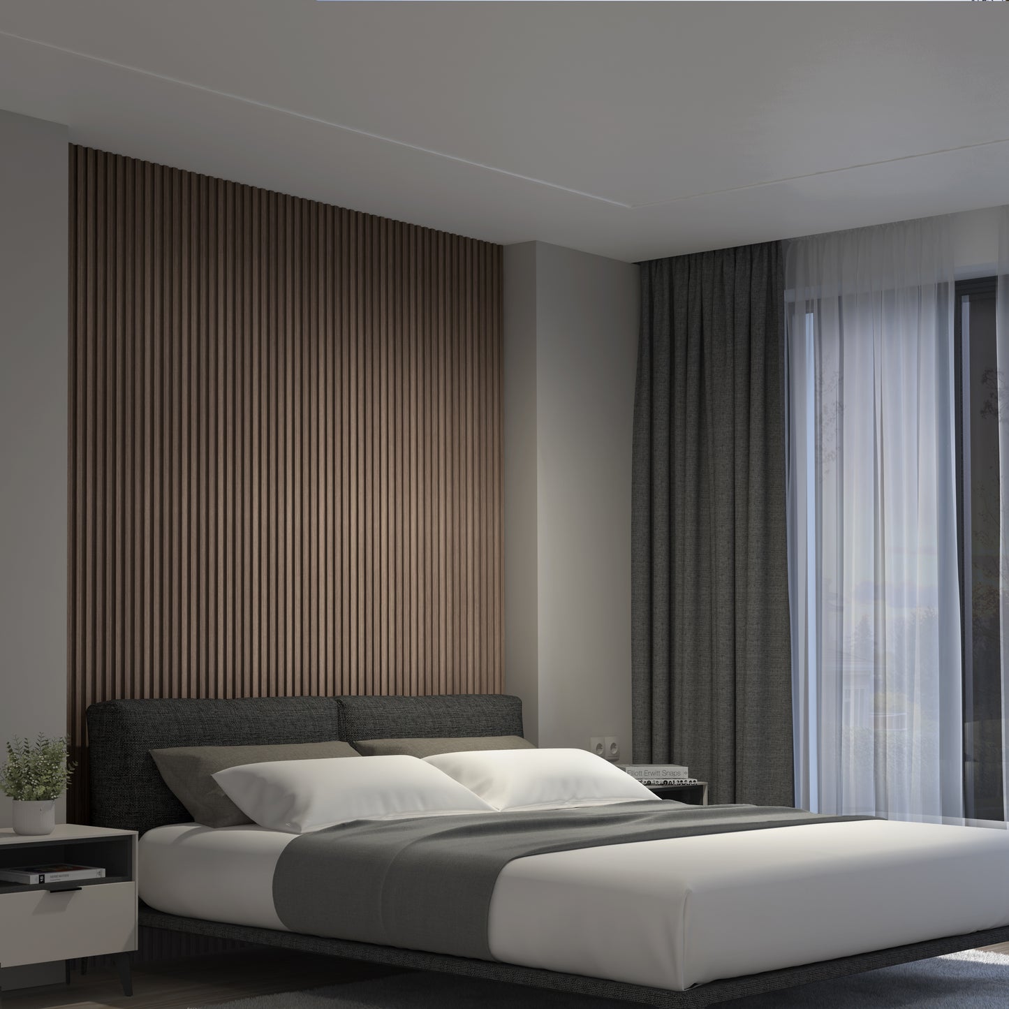 A modern bedroom features a large bed with gray bedding, dark curtains, a nightstand with a plant, natural light from the window, and an Artika Panolok 30.67 ft wall panel kit (pack of 8) creating a stylish wooden slat accent wall.