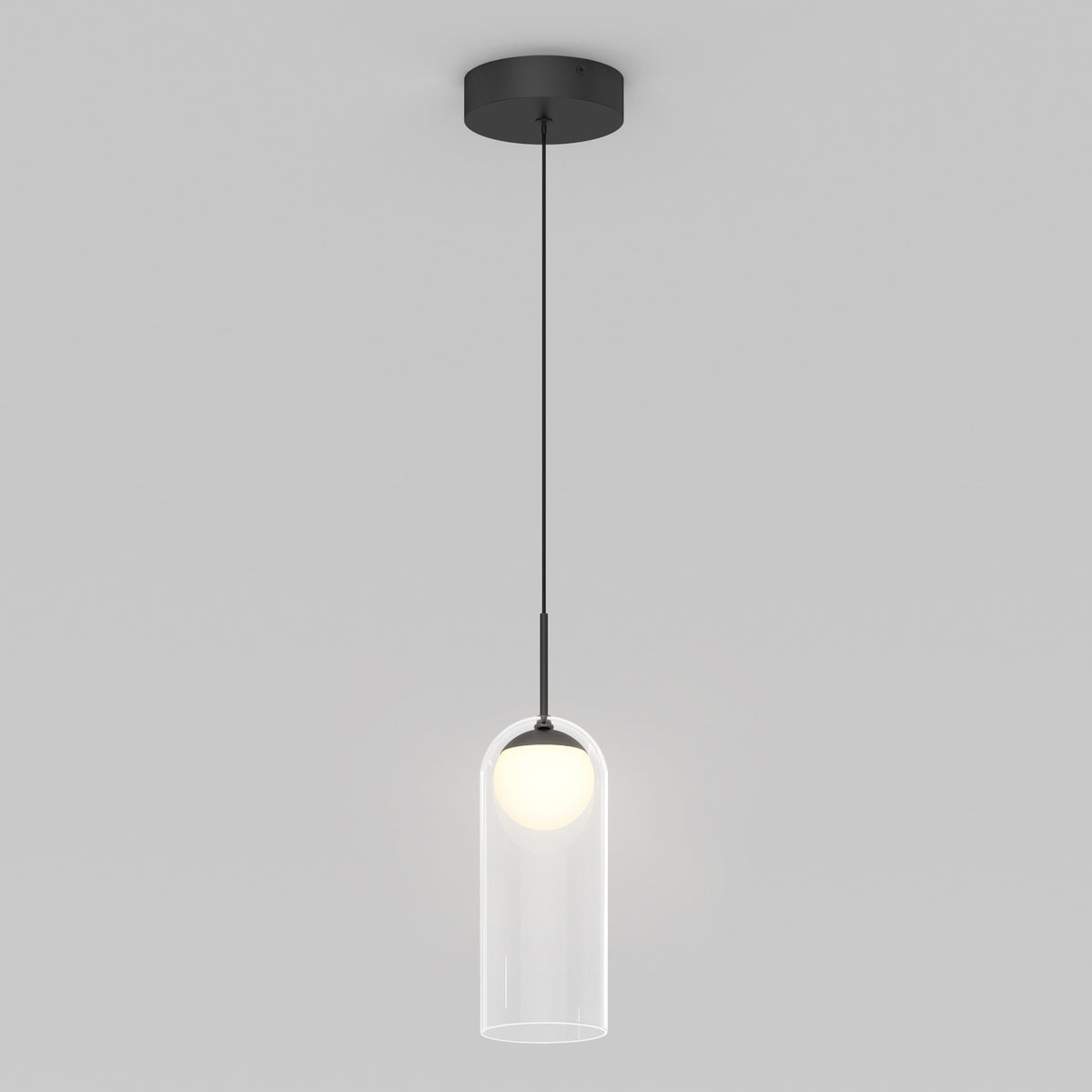 The Artika Mirah LED modern mid-century pendant light 3 CCT features a black ceiling mount, thin black cord, and cylindrical clear glass shade with a white bulb, all set against a plain light gray background.
