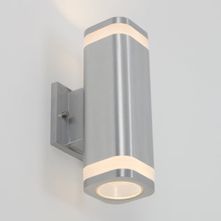 The Artika Mettle LED indoor-outdoor wall light is a modern, stainless steel wall sconce with frosted bands, emitting soft white light from both ends—an elegant, efficient fixture mounted on a square metal base.