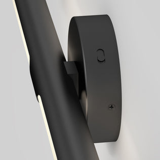 A close-up of the Ilona LED bathroom vanity light 5 CCT by Artika showcases its modern black wall-mounted design with a cylindrical base, visible screw, and sleek minimalist rod.