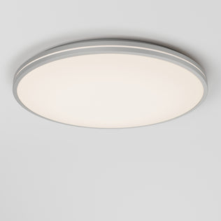 The Artika Athos 21 in. LED flush mount light features a modern round design with a white diffuser and gray trim, emitting a soft, even glow on a white ceiling. Includes remote control for added convenience.