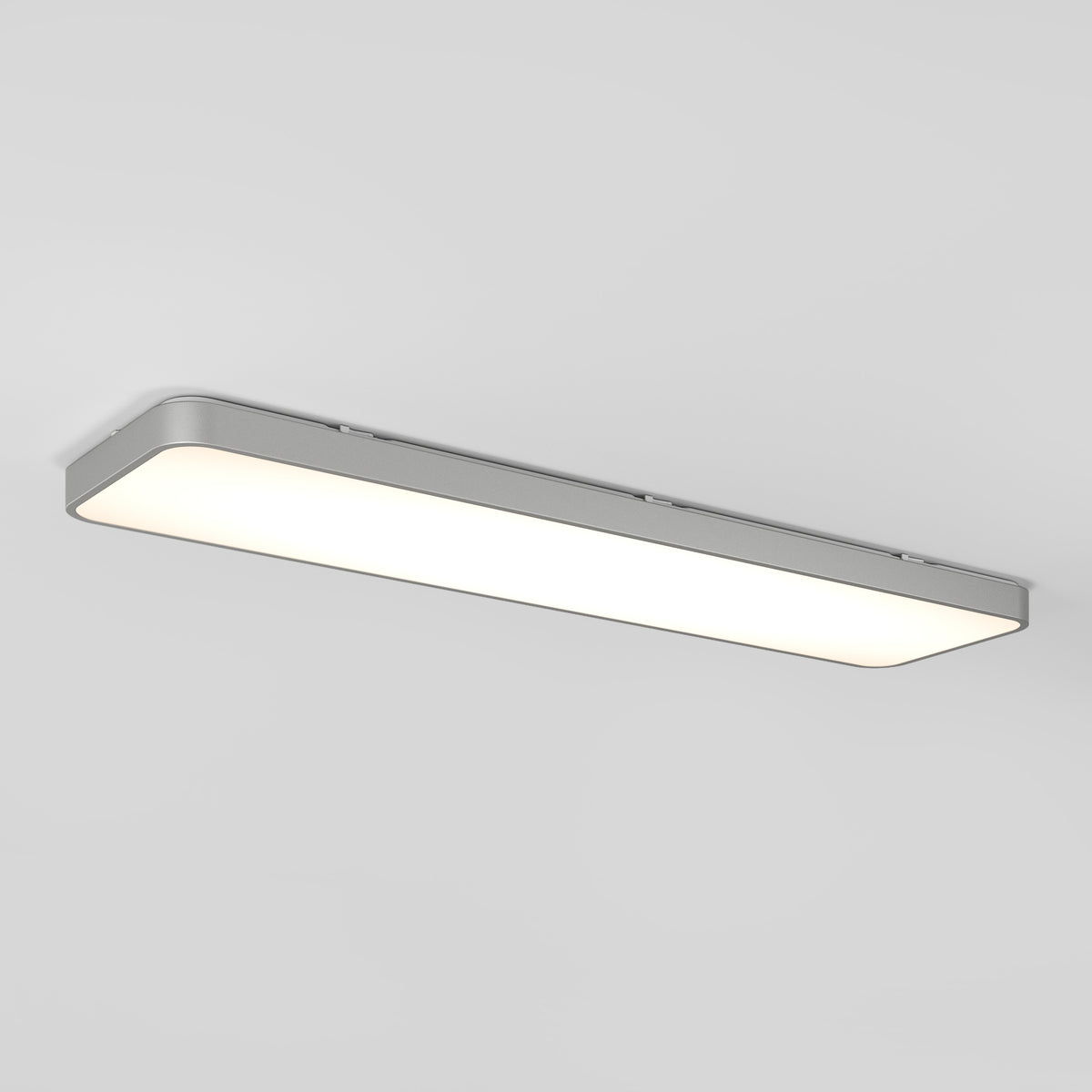 A rectangular, modern ceiling light fixture with rounded corners emits a bright, even white light against a plain white ceiling.