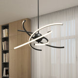 A modern chandelier with curved, glowing LED light bars and a black central sphere hangs from the ceiling in a room with large windows, sheer curtains, and a wooden bookshelf.