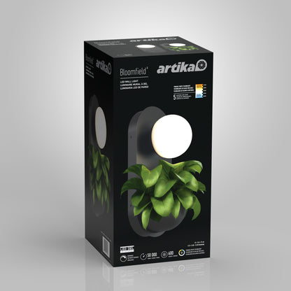 A product box for the Artika Bloomfield LED modern mid-century wall sconce 5 CCT shows the fixture with a round bulb and green plants below, highlighting features, specs, and a 5-year warranty.
