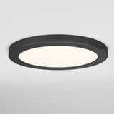 A round, modern black ceiling light fixture with a smooth frame and a diffused white light, mounted on a white ceiling.