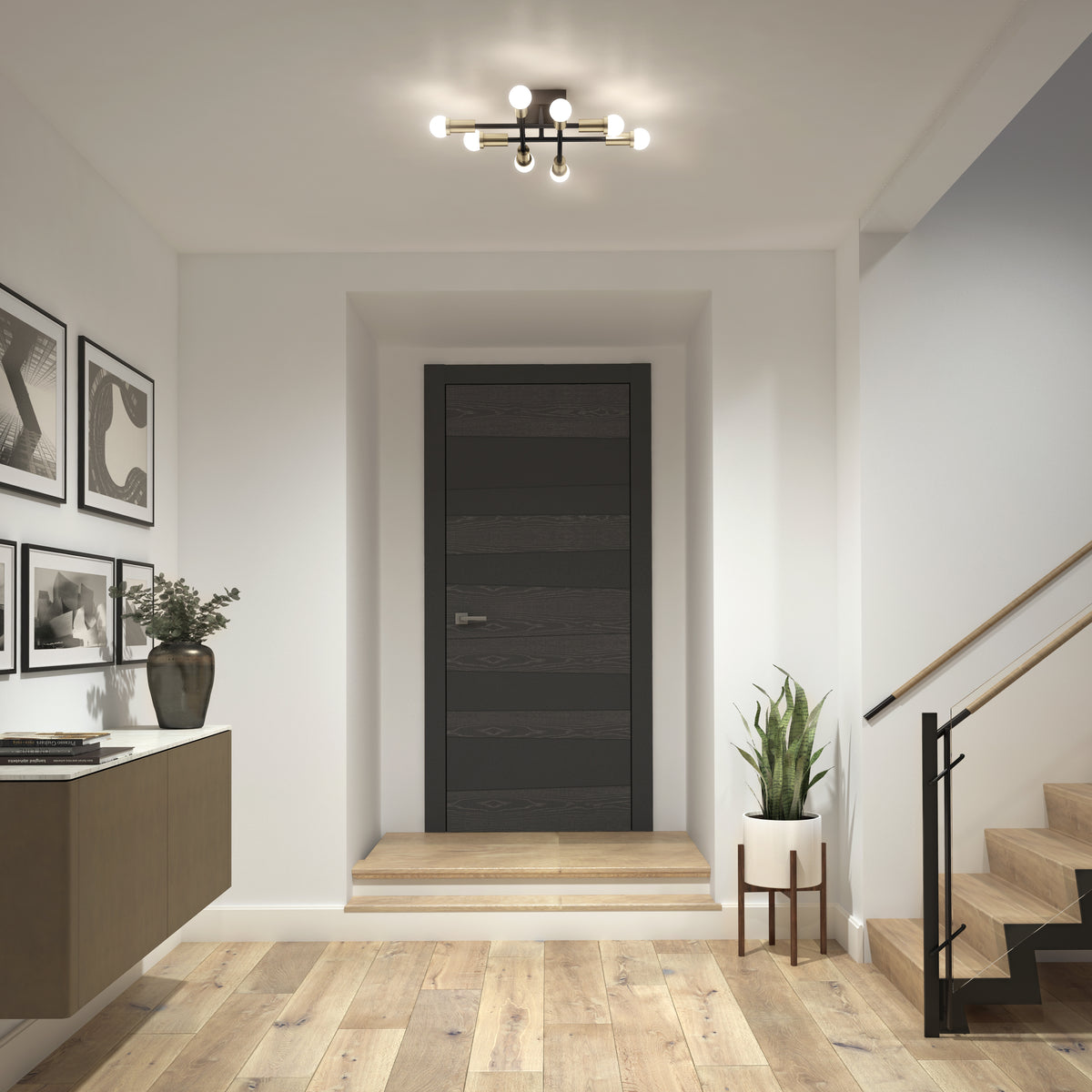 Modern entryway with a dark wooden door, light wood flooring, potted plant, wall art, floating cabinet, and a contemporary ceiling light fixture. Stairs with a black railing are on the right.