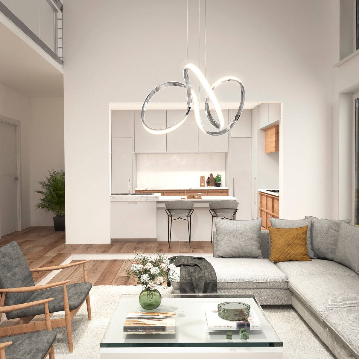 Modern living room with a gray sectional, wood armchairs, glass coffee table with flowers, and the Artika Swirl LED pendant light. The space flows into a minimalist kitchen featuring barstools and neutral decor.
