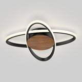 A modern ceiling light fixture with circular LED rings, a wooden central disc, and black metal accents, resembling the shape of Saturn with its rings, set against a plain light gray background.
