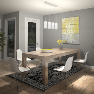 Modern dining room with a wooden table, four white chairs, black and white patterned rug, yellow flowers in a vase, large abstract painting on a gray wall, and the Artika Hologram 4-light LED pendant hanging above the table.