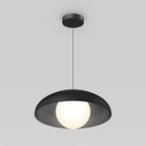 A modern black pendant light with a wide, shallow shade hangs from the ceiling, featuring a glowing white spherical bulb at its center against a plain light gray background.