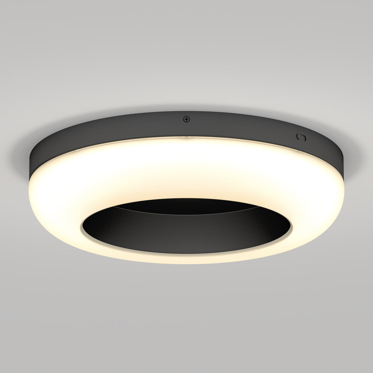 A modern, circular ceiling light with a black central disc and an illuminated white outer ring, mounted on a plain light-colored ceiling.