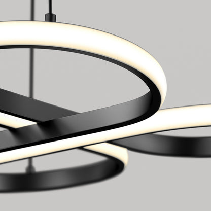 A modern, minimalist ceiling light fixture with intersecting black metal rings and integrated LED lights, suspended against a plain gray background.