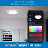 A smartphone displays an app interface for controlling a ceiling light, showing color and brightness options. The ceiling light is on in a modern room. App Store and Google Play icons appear at the bottom.
