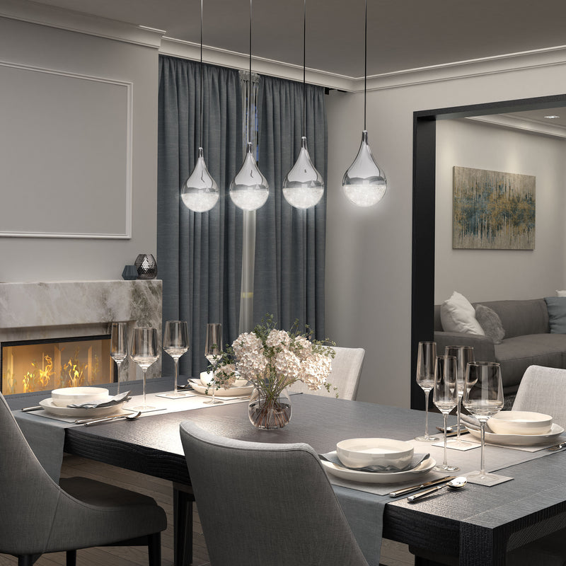 A modern dining room features a set table, four Artika Glitzer 4-light LED pendants overhead, gray chairs, a fireplace on the left, blue curtains, and a living room with a sofa and abstract wall art in the background.