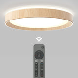 A modern, circular ceiling light with a wooden trim is shown, emitting a soft glow. Below it, a wireless remote control displays various buttons and an illuminated symbol indicating wireless connection.