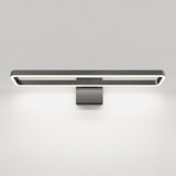A modern black wall-mounted LED light fixture with a rectangular frame emits a soft white glow, illuminating the wall below against a plain white background.