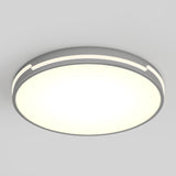 A round, modern ceiling light fixture with a glowing white center and a sleek gray rim, mounted on a plain light gray ceiling.