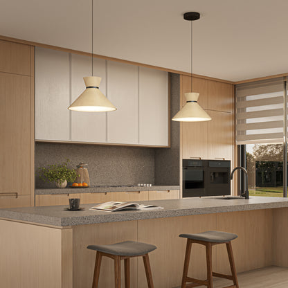 Modern kitchen with light wood cabinets, a gray countertop island with two gray stools, Inoa LED pendant lights by Artika above, built-in black ovens, a sink, a book on the counter, and a window with a dual-layer roller blind.