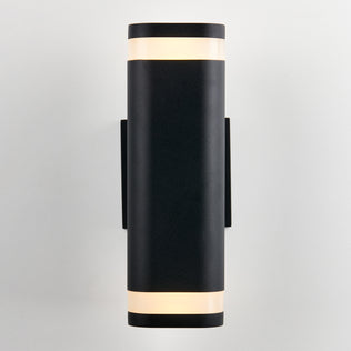 The Artika Mettle LED indoor-outdoor wall light is a modern black cylindrical sconce with frosted diffusers at the top and bottom, shown mounted vertically on a plain white wall.