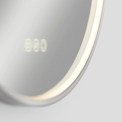 A close-up of the Artika Royce LED mirror 3 CCT with defogger, featuring a round illuminated frame and built-in digital clock display reading 8:00, reflected faintly on the mirror’s surface.