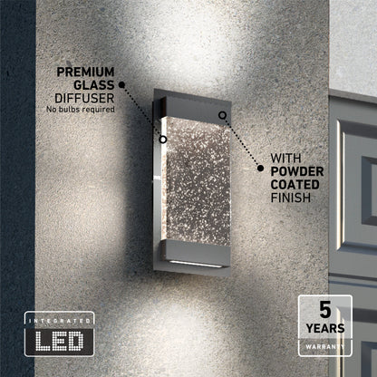 The Artika Essence Glow Box indoor-outdoor LED wall light, featuring a premium glass diffuser and powder-coated finish, is mounted on a textured wall. Integrated LEDs mean no bulbs required, plus it comes with a 5-year warranty.