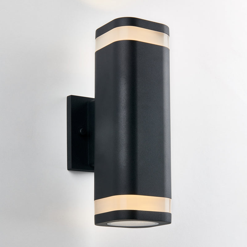 The Artika Mettle LED indoor-outdoor wall light features a modern black design with rounded edges and two frosted bands that emit soft light, shown mounted on a white wall.