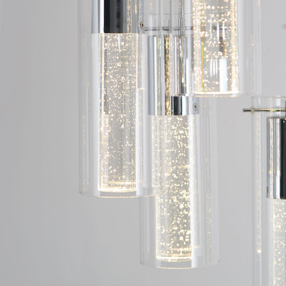 Close-up of Artikas Bubble Swirl 5-light pendant, featuring cylindrical glass shades with chrome accents and tiny bubbles illuminated inside, creating a sparkling effect against a plain background.