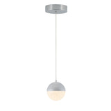 A modern pendant light with a round silver ceiling mount, a thin hanging cord, and a spherical light fixture that is half silver and half frosted glass, emitting a soft glow.