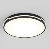 A modern, circular ceiling light fixture with a black rim and a smooth, glowing white center, mounted on a plain light gray ceiling.