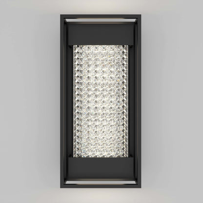 The Artika Glam indoor-outdoor LED wall light is a rectangular black sconce with a center panel of sparkling crystal-like elements, glowing bright white against a plain light gray background.