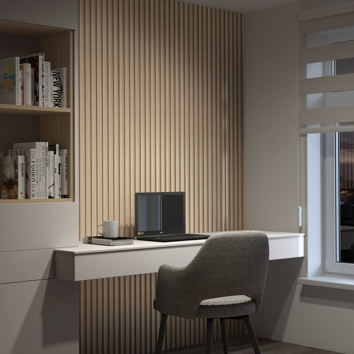 A modern home office features a gray chair at a white desk with a closed laptop, notebook, and coffee mug. Wooden slats decorate the wall, and shelves with books are on the left. A window with blinds is on the right.