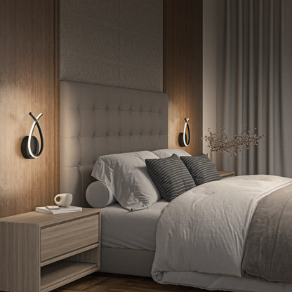 Modern bedroom with a tufted headboard, neutral bedding, two gray accent pillows, wooden nightstands (one with a cup), floor-length curtains, soft lighting, a vase with branches, and Artika Gamma modern LED wall sconce 5 CCT on the wall.