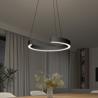 An Artika Vance modern LED pendant light (3 CCT) hangs over a wooden dining table with a glass vase of dried flowers. The room features beige curtains, a large window, and built-in shelves in the background.