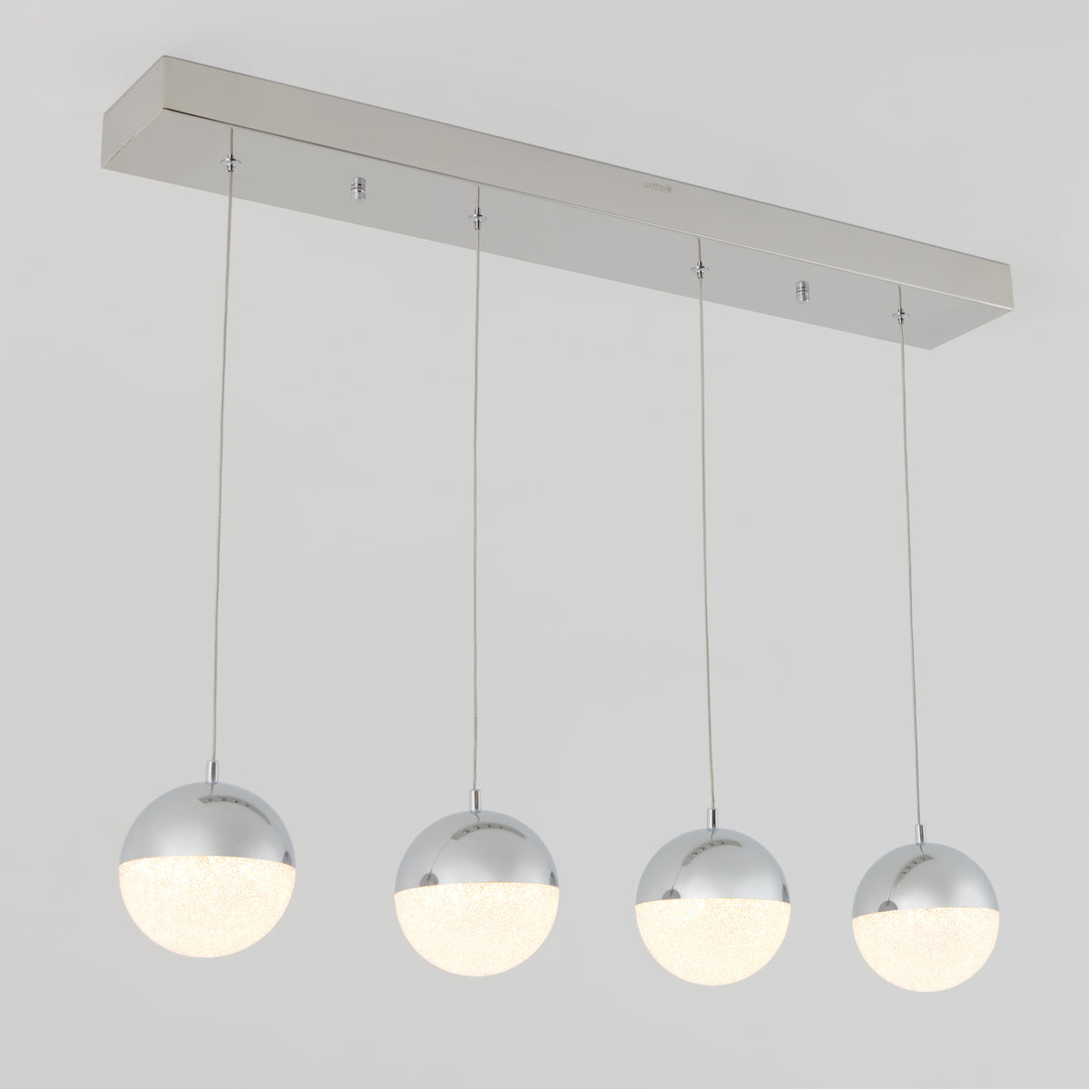 The Artika Sparkle 4-light LED pendant features four spherical, chrome-finished lights with frosted lower halves, arranged in a row on a rectangular metal base for a modern ceiling fixture.