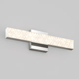 A modern, rectangular wall-mounted LED light fixture with a textured, frosted front panel and a sleek chrome base, set against a plain light gray wall.