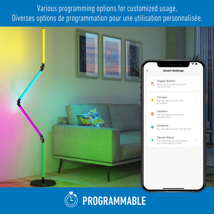 A modern living room features the Artika Fitch smart foldable RGB LED gaming floor lamp next to a sofa. A smartphone displays smart customization options. Text above reads, “Various programming options for customized usage.”.