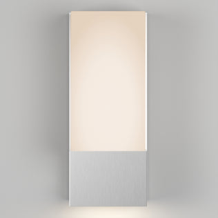 The Artika Dixon indoor-outdoor LED wall light features a rectangular frosted panel atop a brushed metal base and, when mounted on a light gray wall, emits a soft, warm glow.
