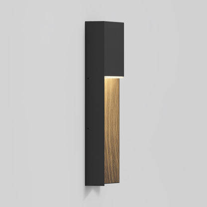 The Artika Howel modern LED indoor-outdoor wall light 5 CCT features a black rectangular frame with a vertical wood accent, casting downward light, and is shown mounted on a plain light gray wall.