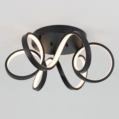 The Artika Swirl Ribbon flush mount light features three intertwined LED loops in black, mounted on a round black base, emitting a soft white glow against a light gray background.