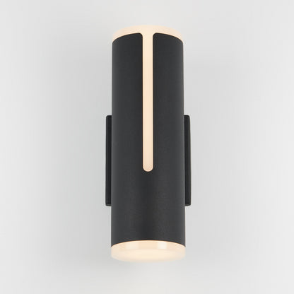 The Artika Linea modern indoor-outdoor LED wall light is a sleek black cylinder with soft, warm top and bottom glows and a thin vertical front light strip, shown mounted on a plain white background.